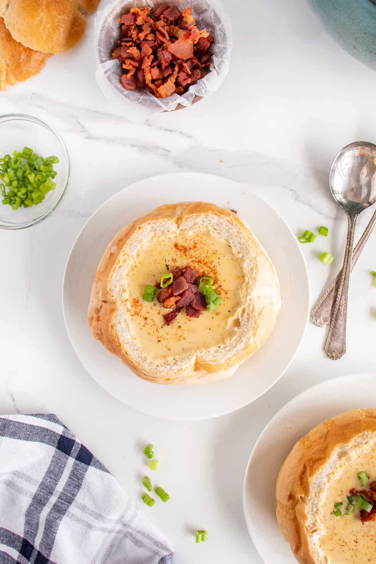 beer cheese soup in a bread bowl garnished with bacon and green onion