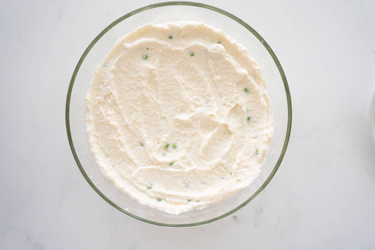 salad dressing on top of peas in a bowl