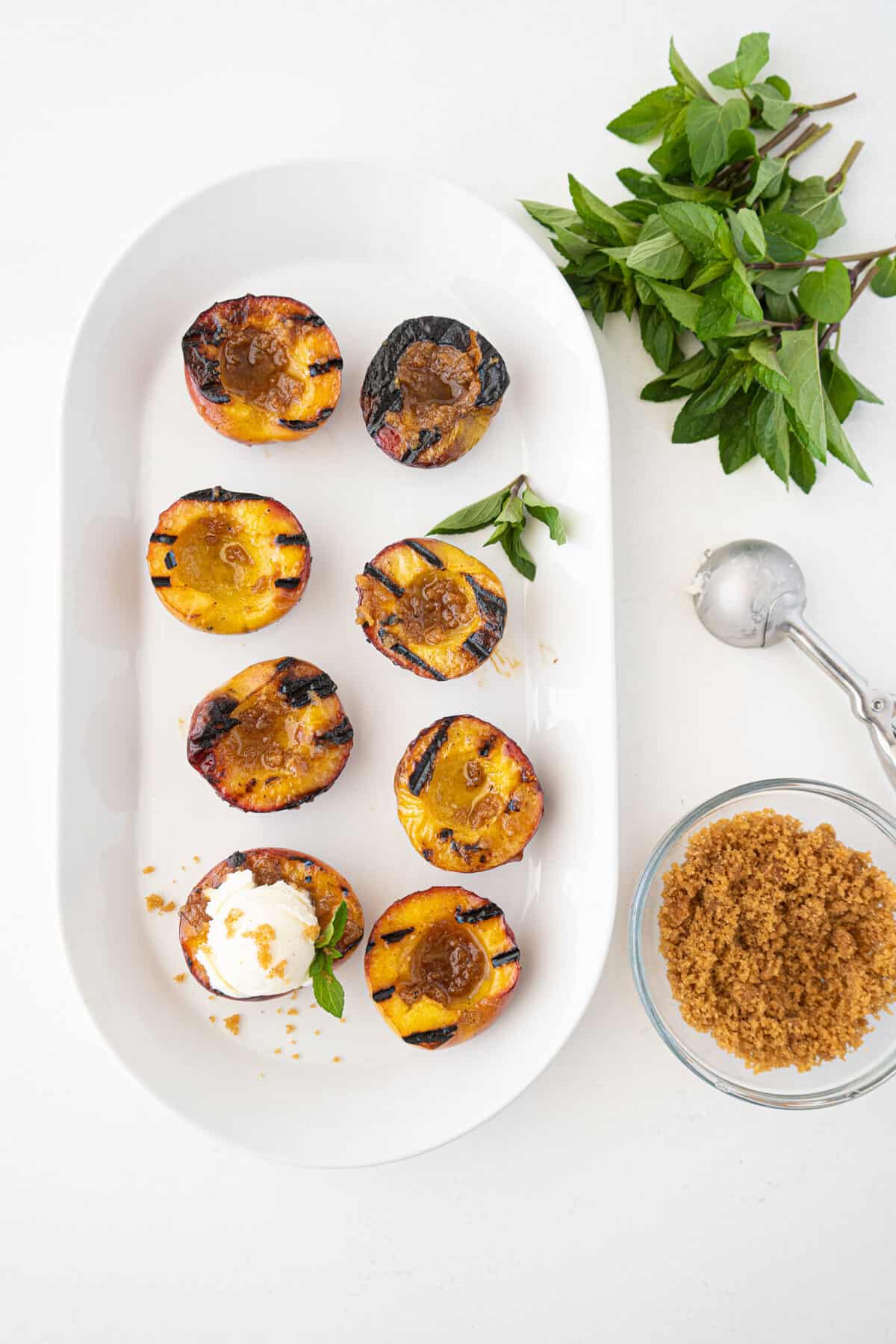 grilled peaches on a white platter