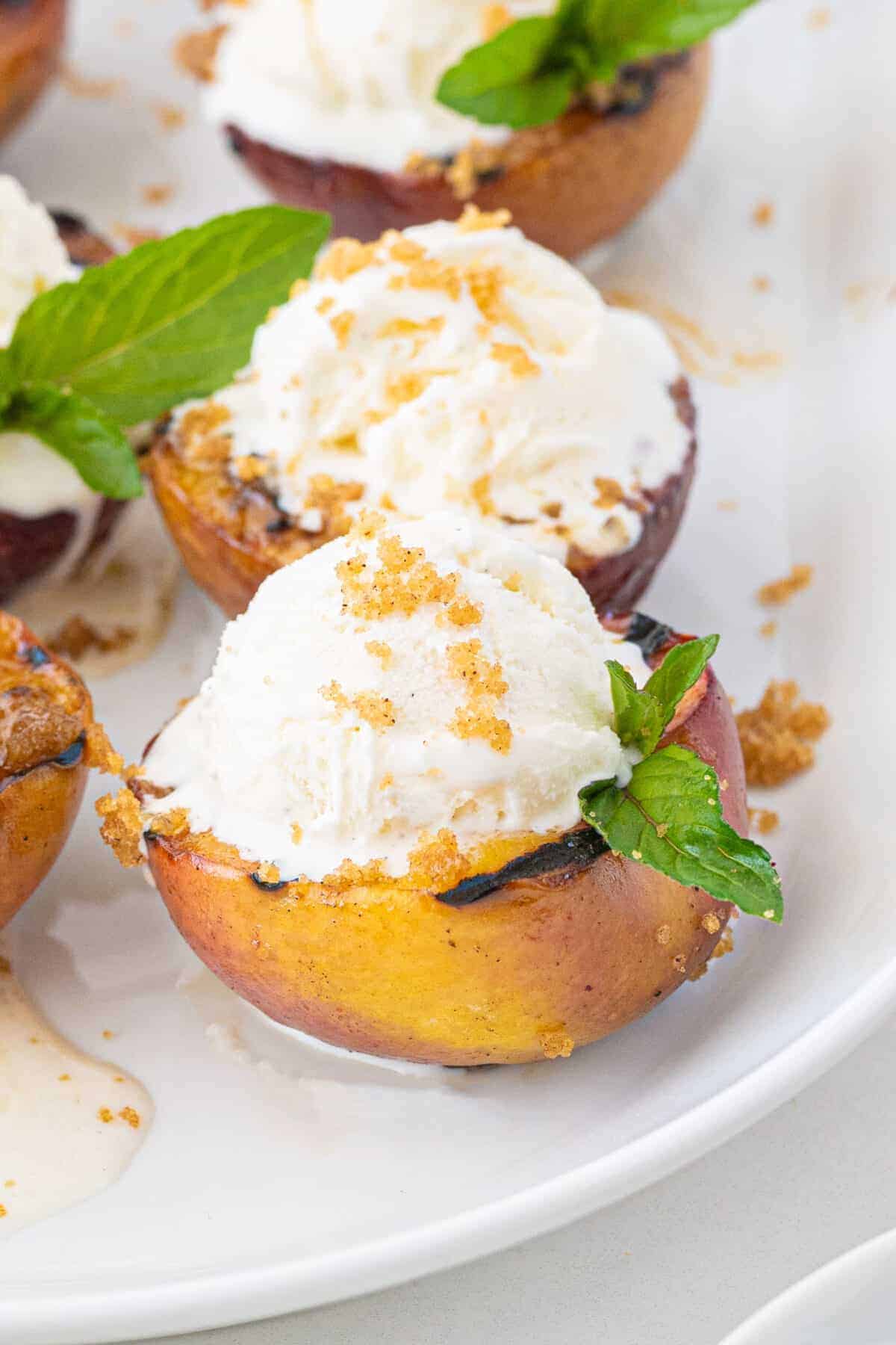 grilled peaches topped with vanilla ice cream and crumbly topping