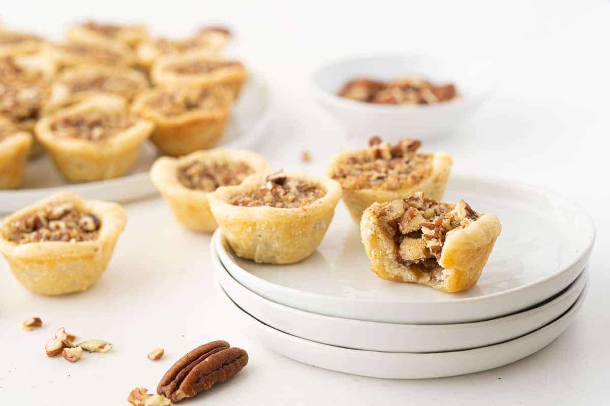 Mini pecan tassies with buttery crust and gooey pecan filling, perfect bite-sized treats.