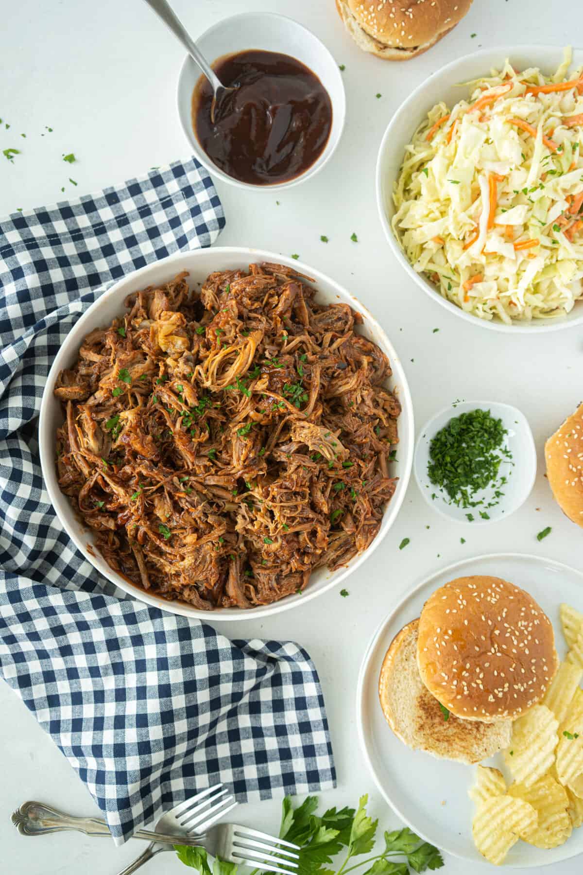 pulled pork in a bowl with buns around it