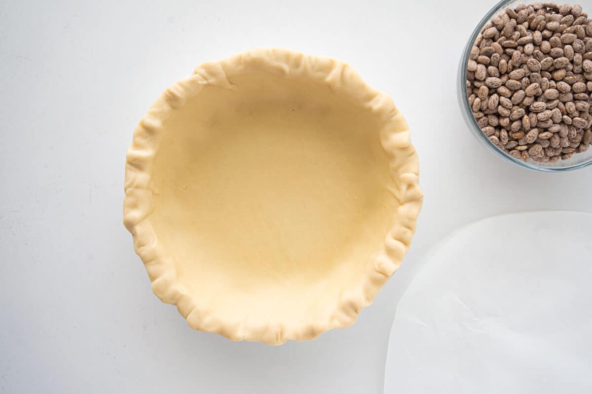 blind baked pie crust in a pie plate with crimped edges