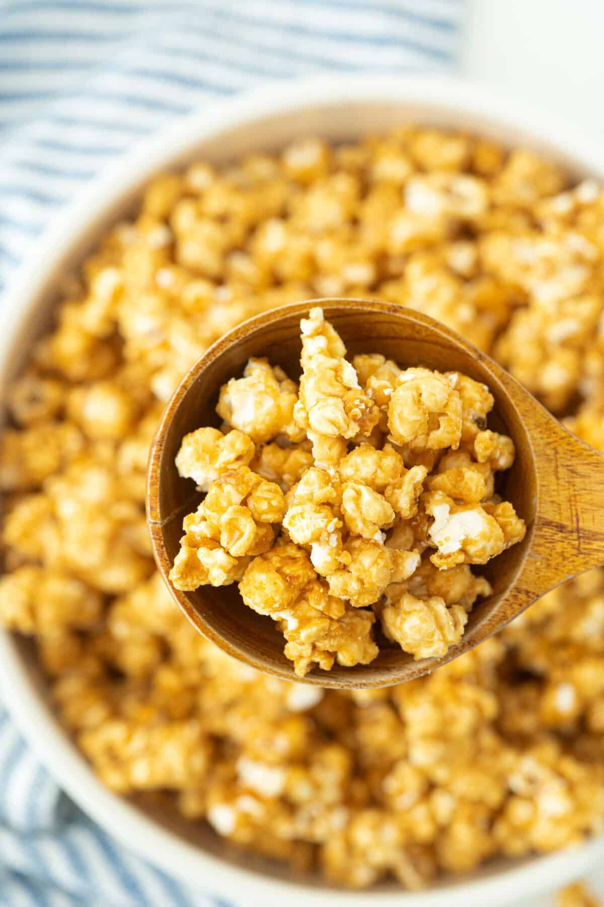 a wooden spoon full of caramel popcorn