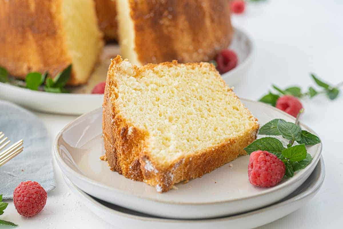 Tall, airy classic chiffon cake dusted with powdered sugar on a rustic plate.