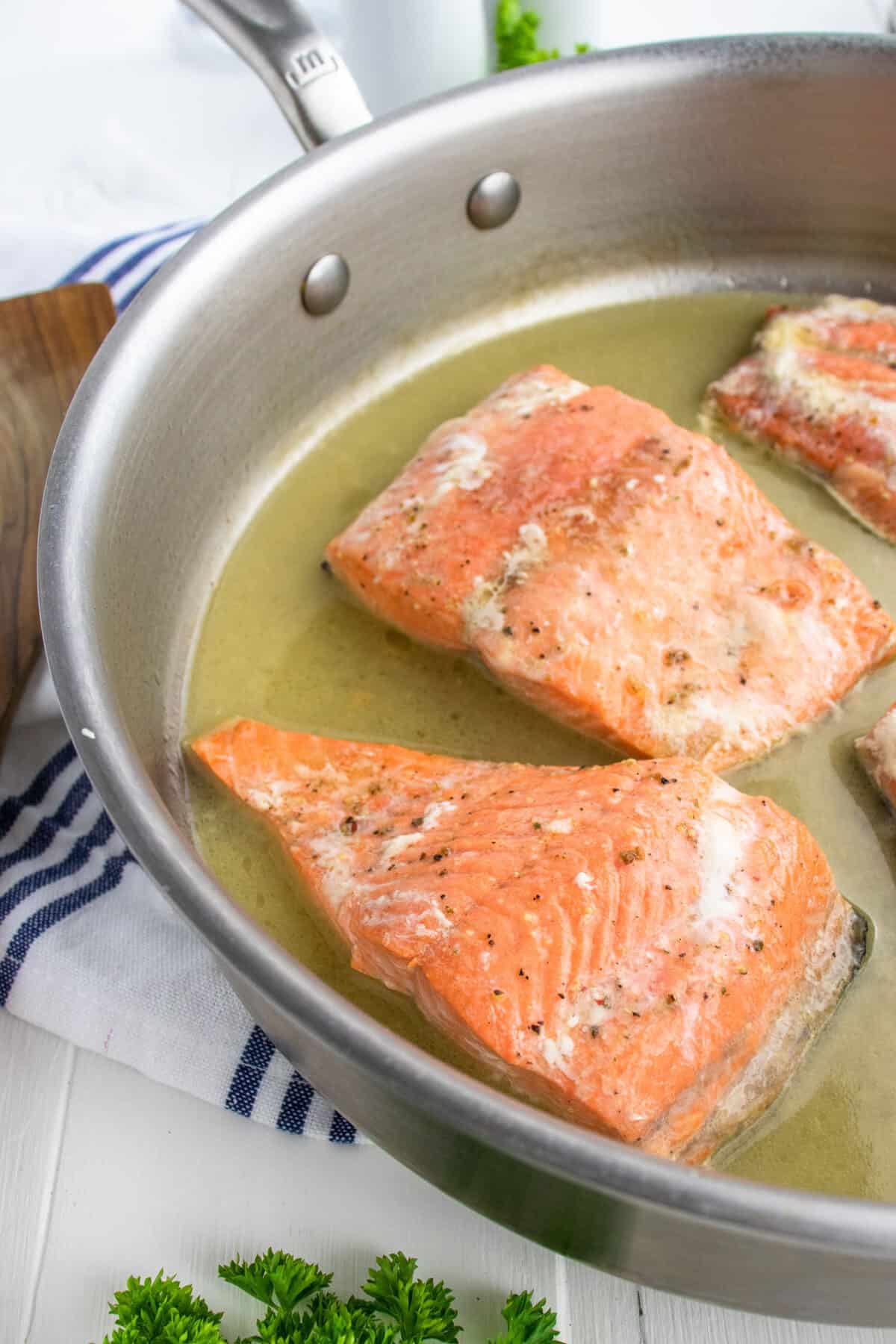 poaching salmon fillets in a pan