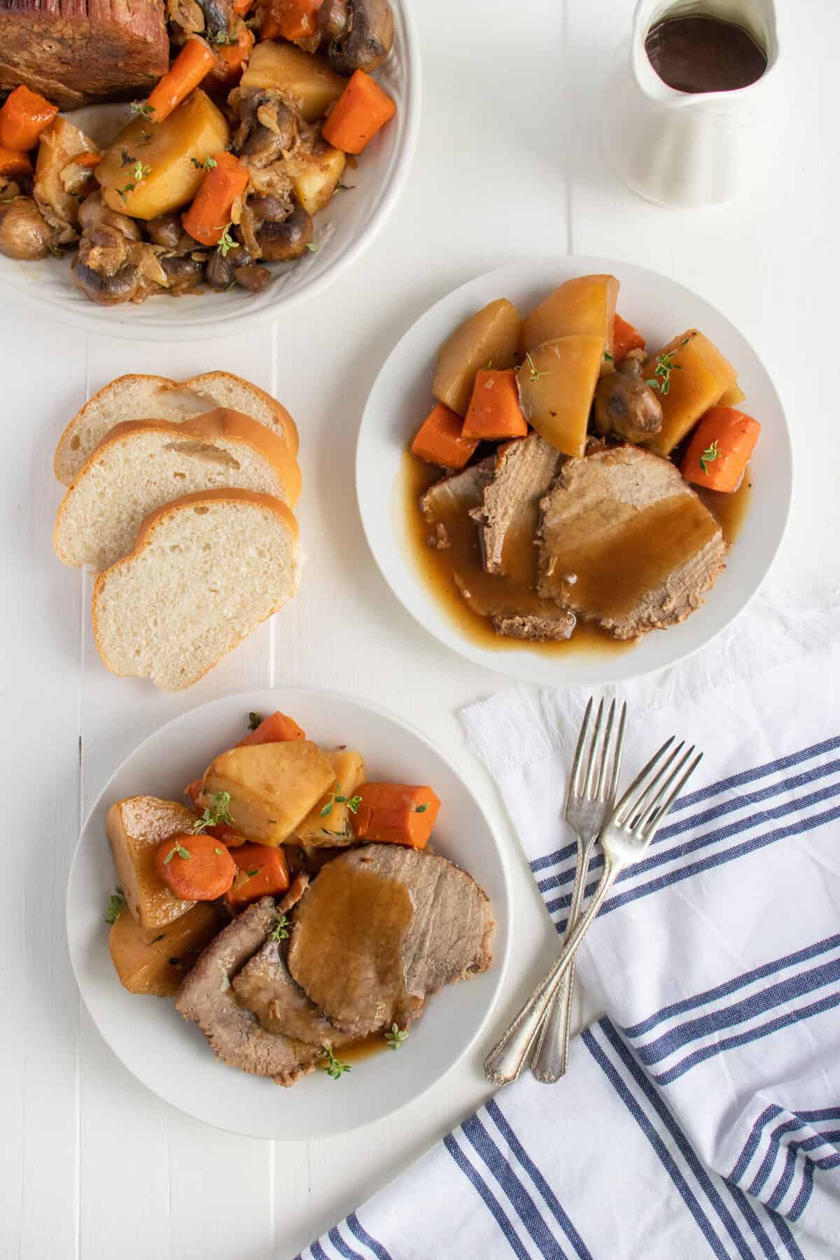 rump roast on two white plates with gravy on top