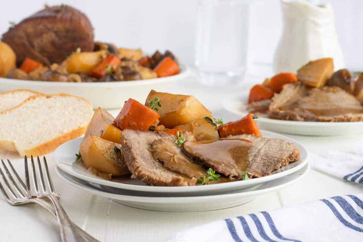 rump roast on a white plate with gravy on top