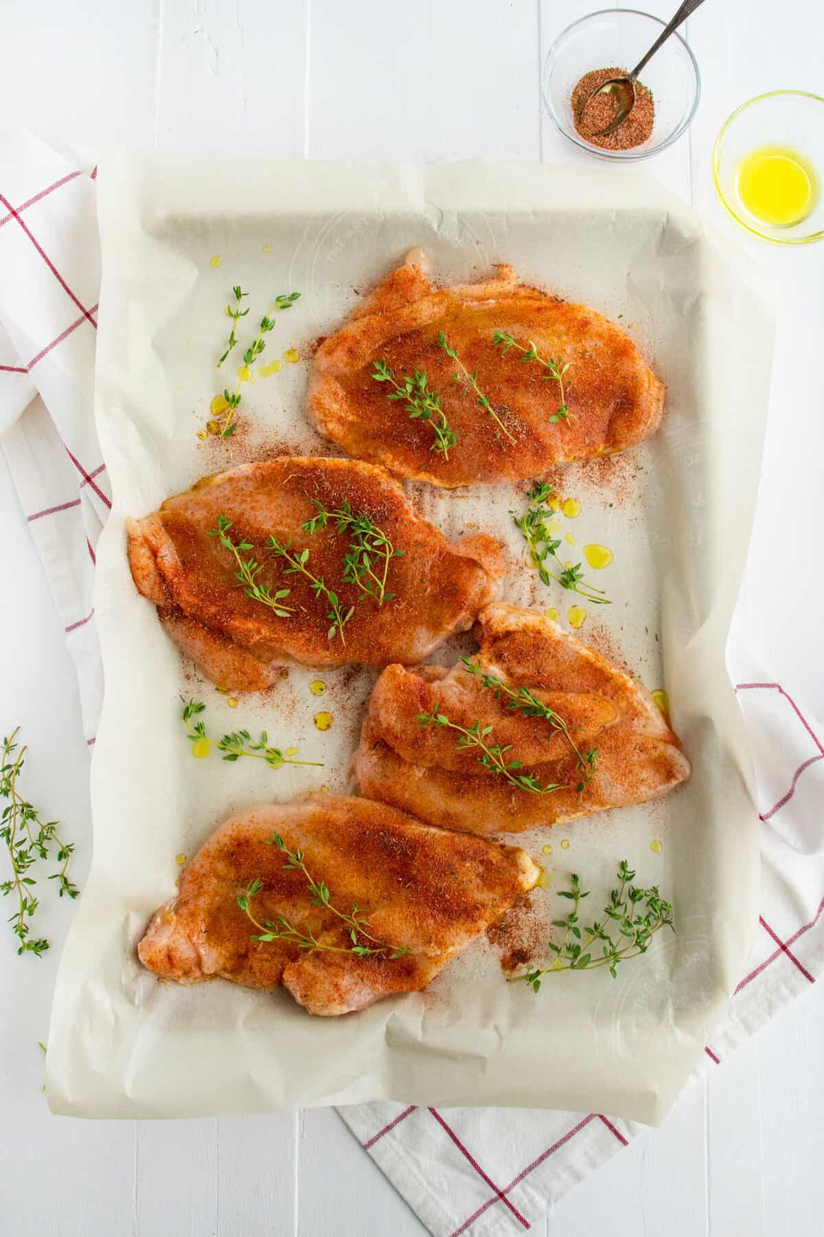 raw chicken breasts on a baking sheet 