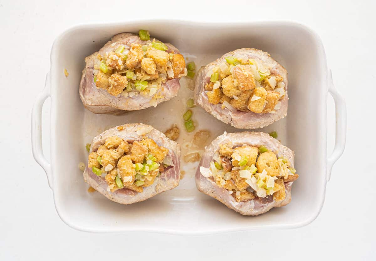 raw stuffed pork chops in a baking dish before baking 