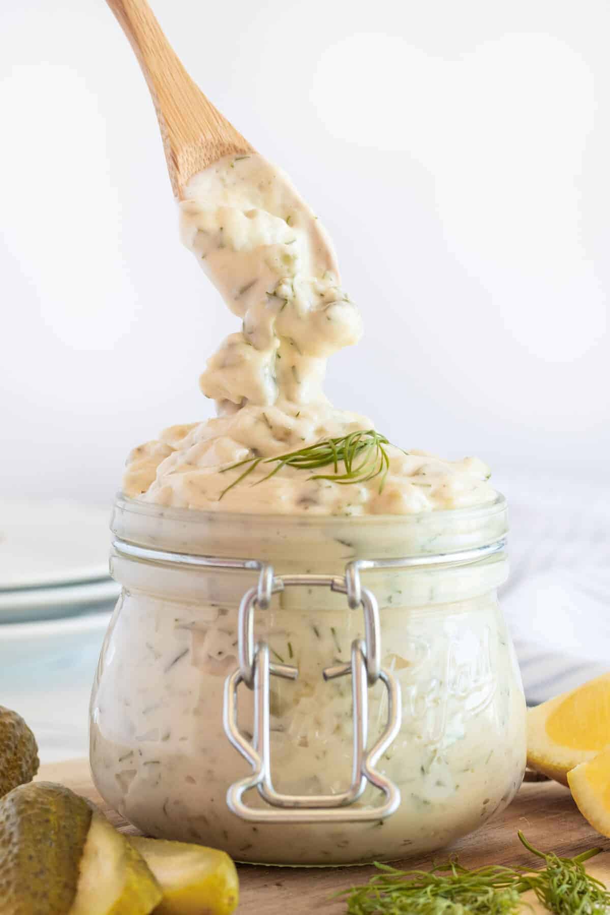 spooning tartar sauce into a jar 