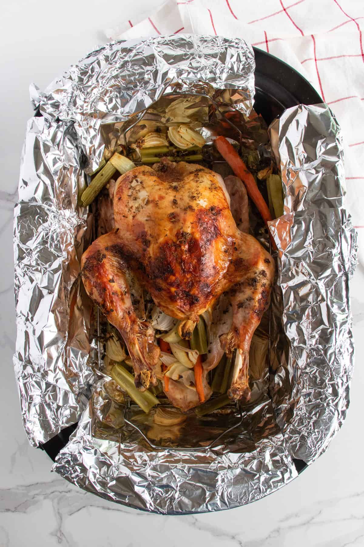 roasted Thanksgiving turkey in aluminum foil in a roaster