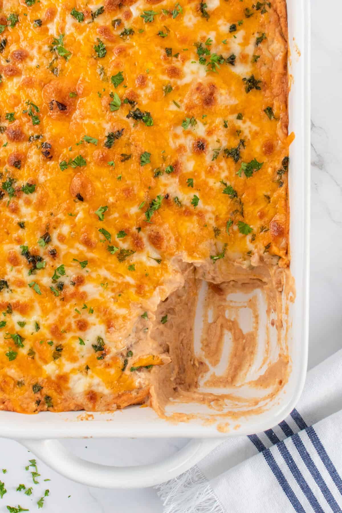 baked cheesy bean dip in a white baking dish