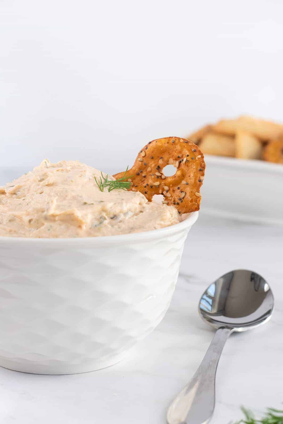 bowl of smoked salmon dip with a pretzel in it 