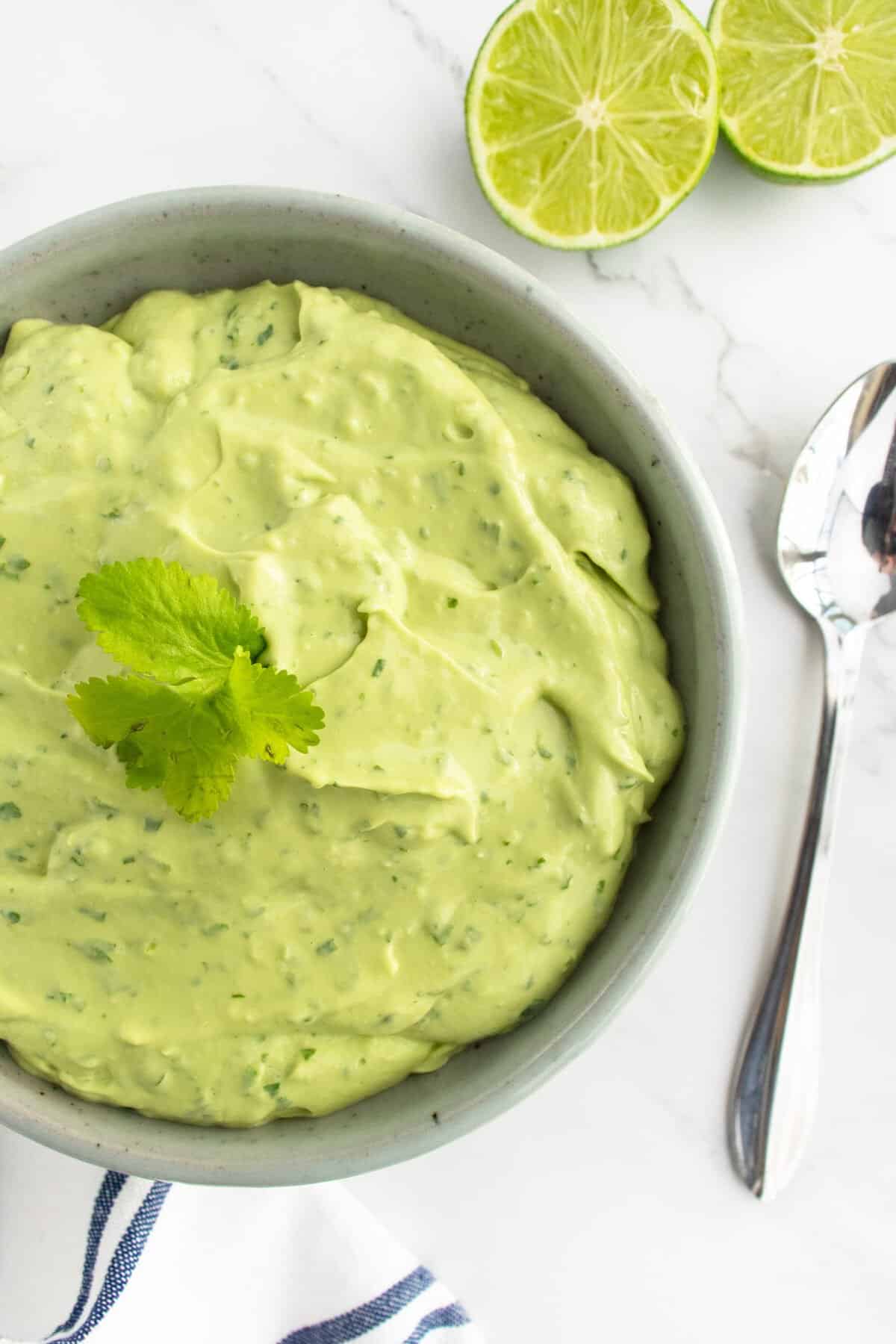 Avocado Crema in bowl with spoon beside it