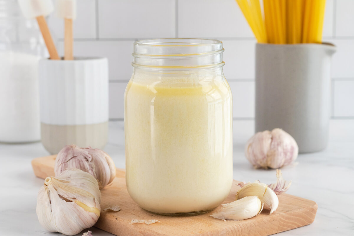 Garlic alfredo in jar on cutting board