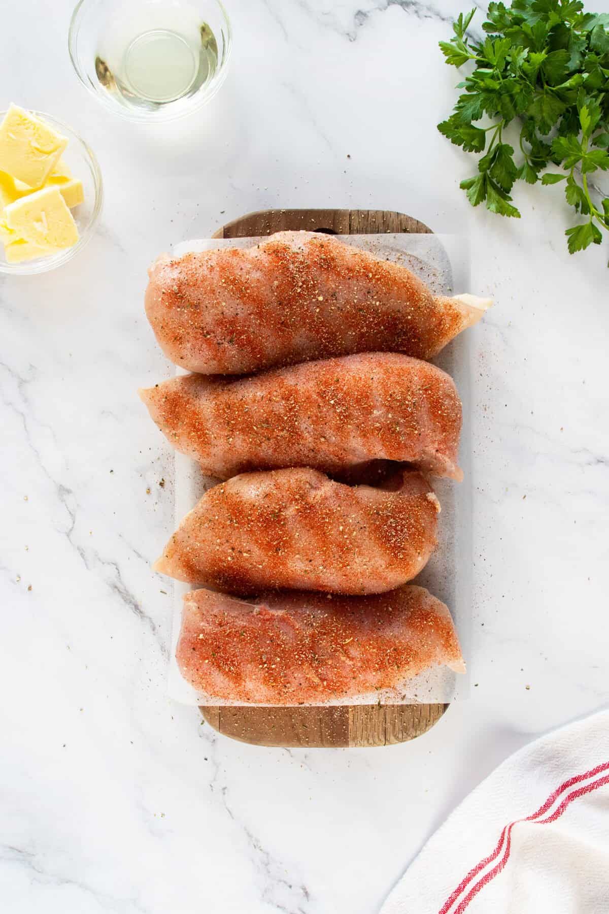 Pan fried chicken breast seasoned on cutting board