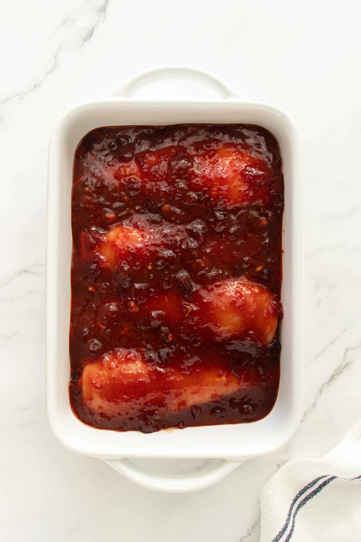 Cranberry chicken uncooked in baking pan