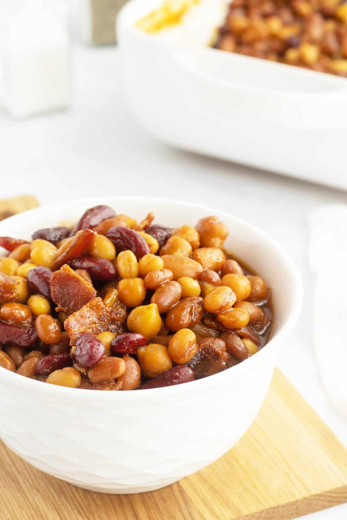 Homemade baked beans in a white bowl closeup