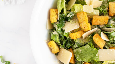 Kale caesar salad close up on white plate