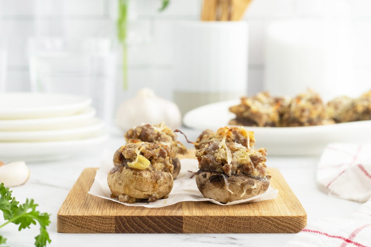 Sausage stuffed mushrooms on a cutting board