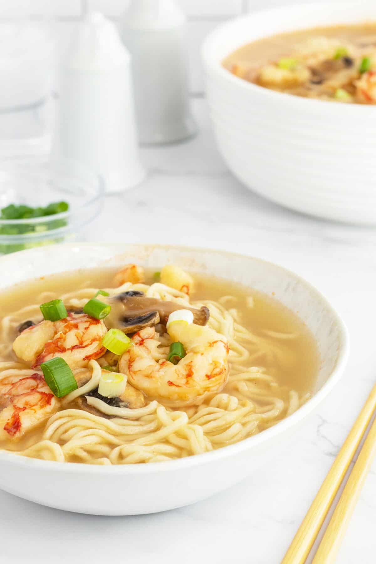 Shrimp soup in a bowl with chopsticks at the side