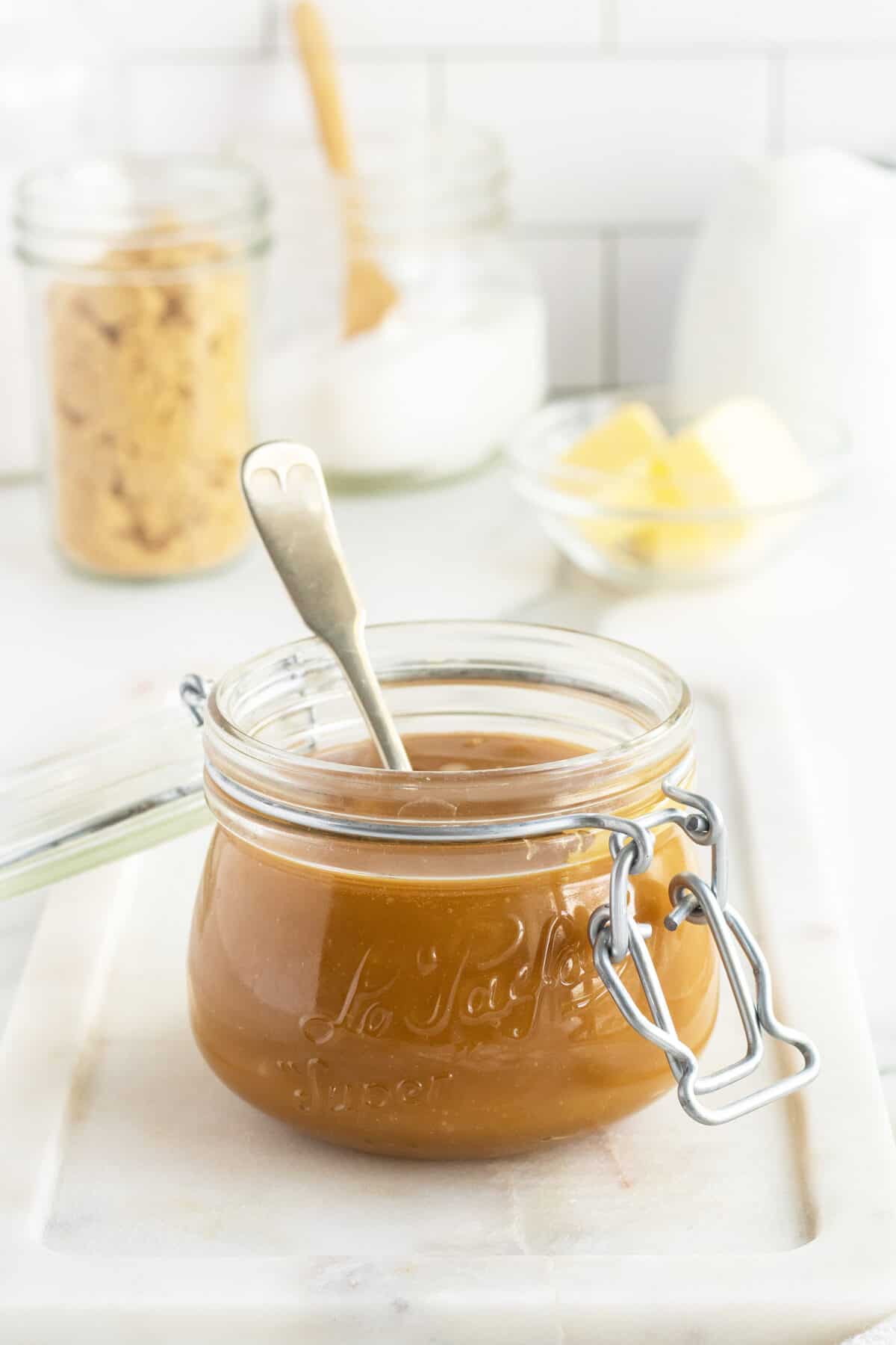 Salted Caramel Sauce in a jar with a spoon inside