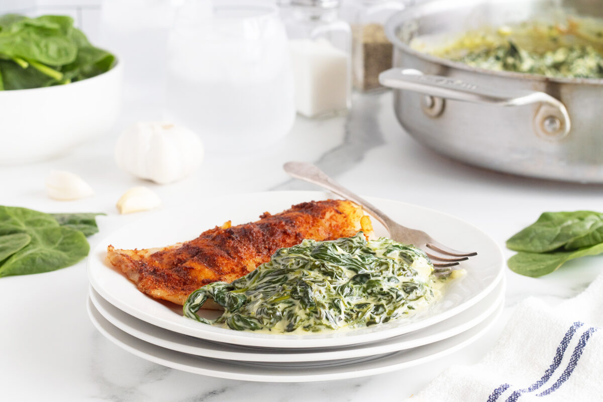 Creamed spinach with fish on a white plate