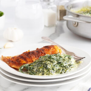 Creamed spinach with fish on a white plate