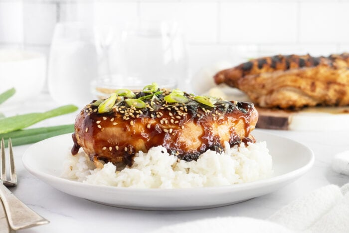 Grilled teriyaki chicken on a white plate with rice