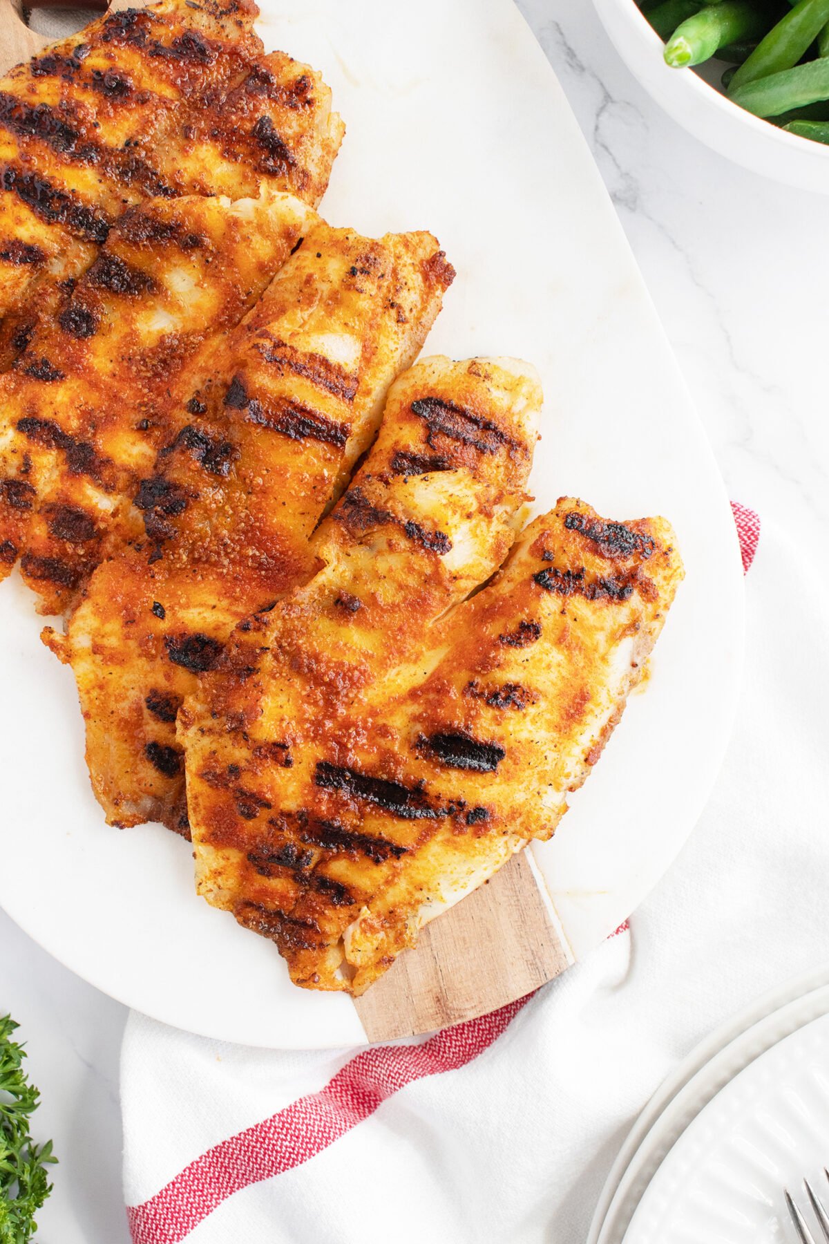 Grilled tilapia on a white platter