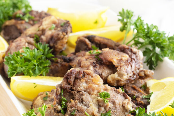 Fried Chicken Livers with parsley on a white platter
