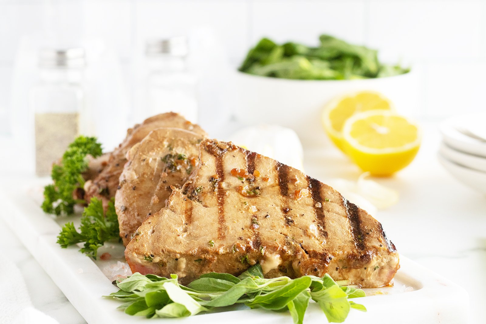 Sliced grilled tuna steaks served medium-rare with seasoning.