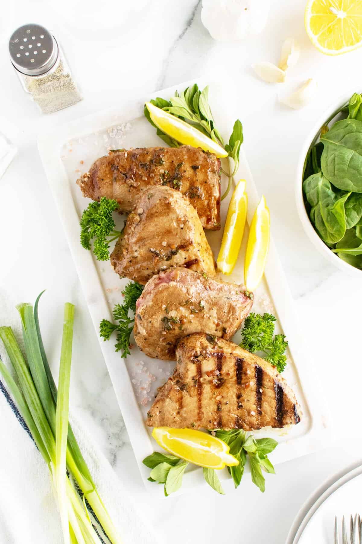 grilled tuna steaks lined up on a white platter
