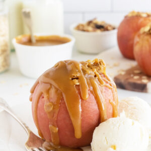 Baked apple with caramel drizzled on top with ice cream
