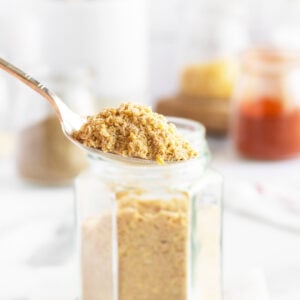 Onion soup mix in a spoon by a jar
