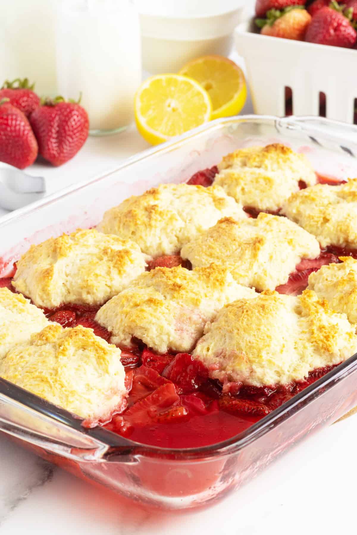 Strawberry Cobbler in a baking pan with one piece missing