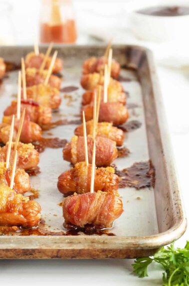 brown sugar bacon wrapped smokies lined on a baking pan