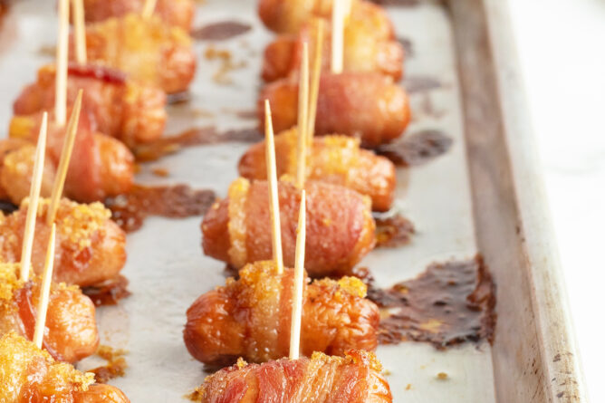 brown sugar bacon wrapped smokies lined on a baking pan