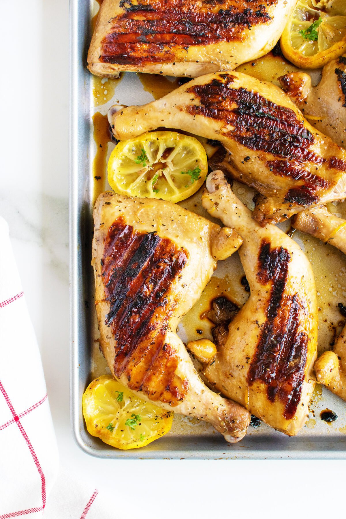 chicken marinated and grilled with slices of lemon on a pan