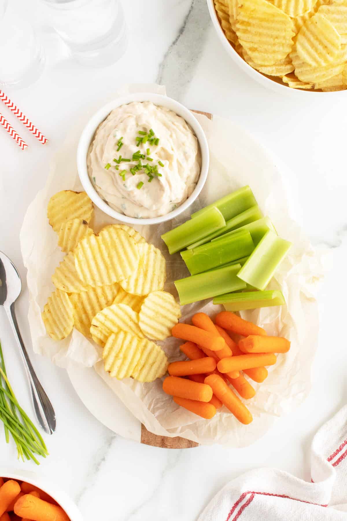 french onion dip on a tray with carrots celery and chips