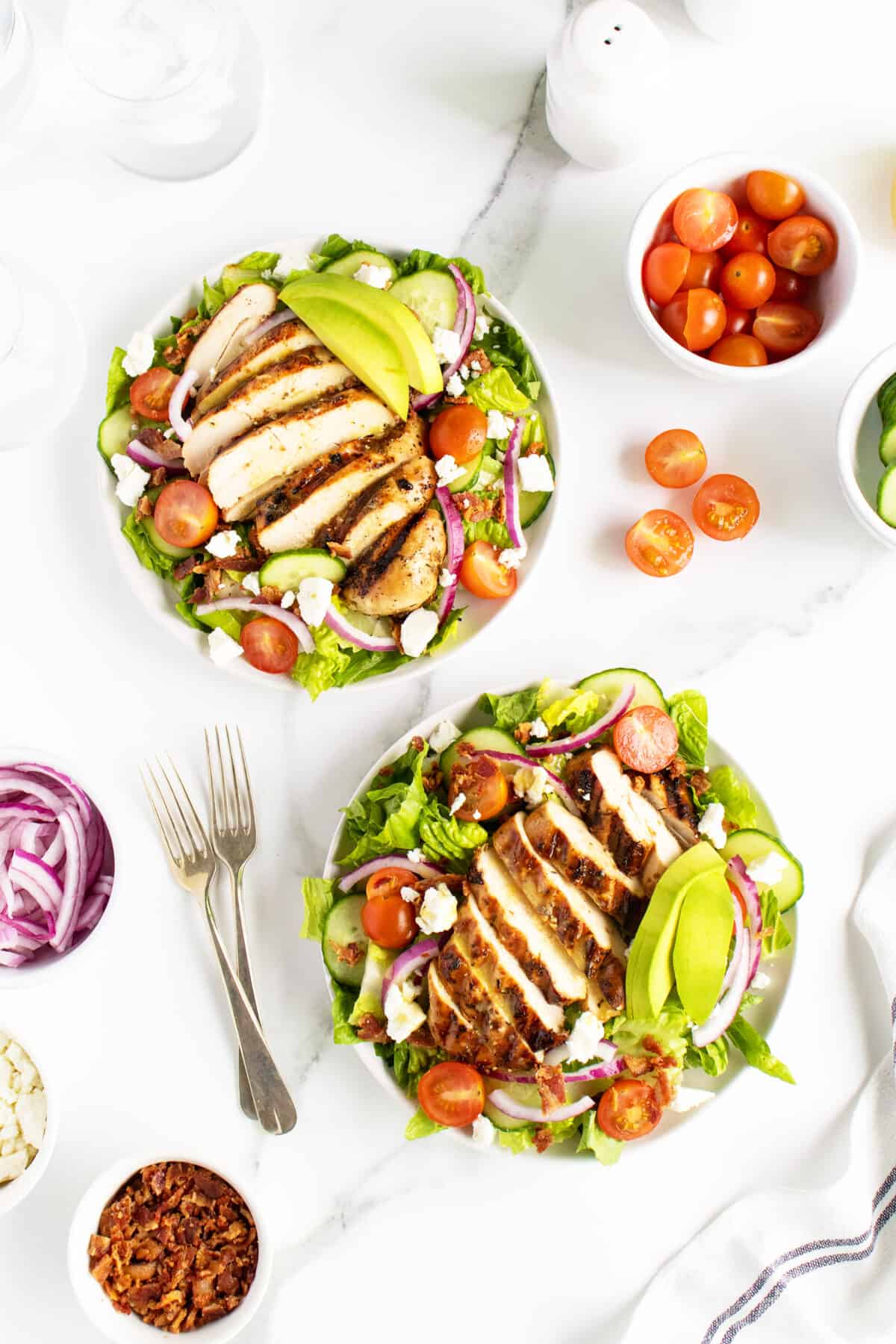 grilled chicken salad on two separate white plates