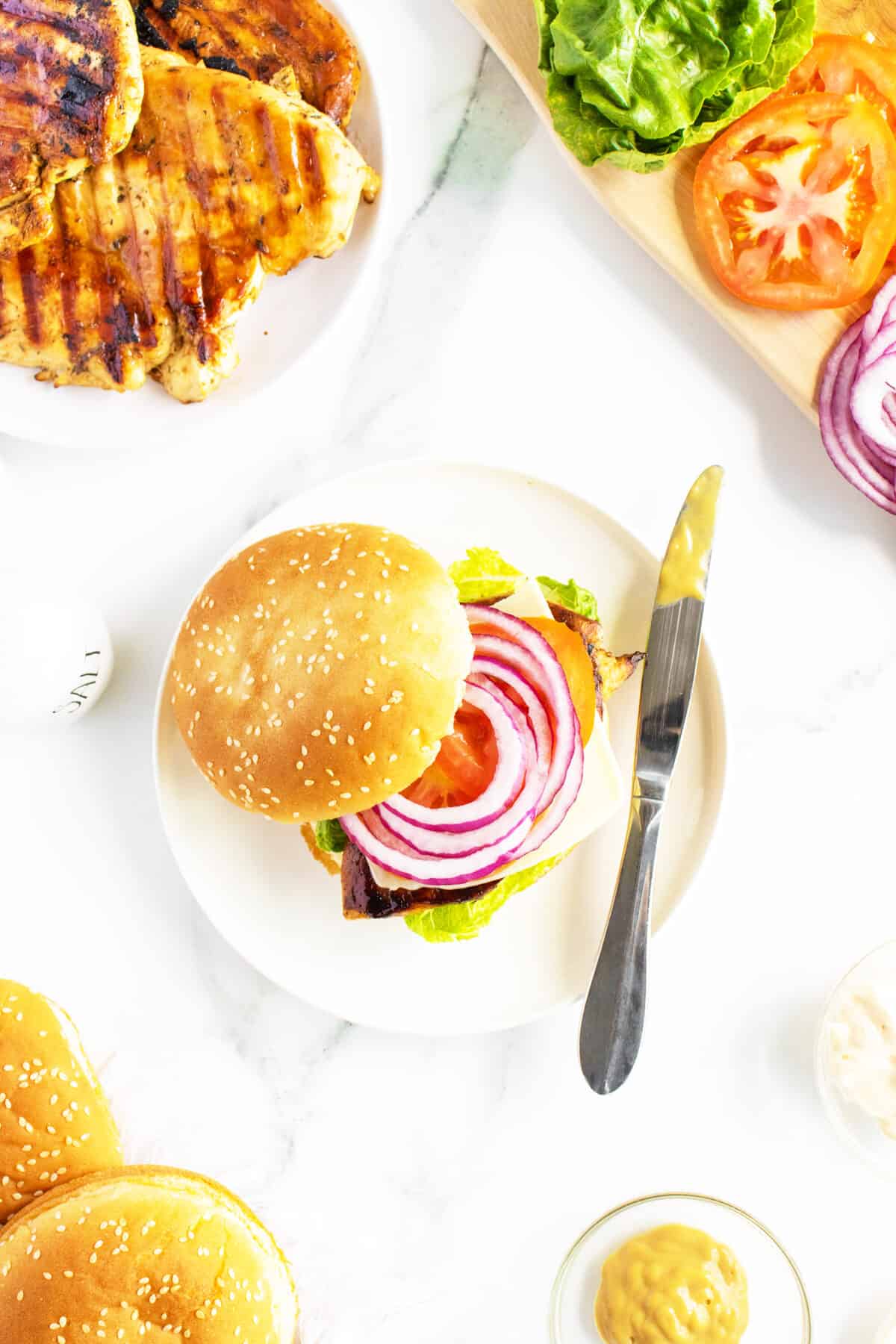 grilled chicken sandwich on a plate with the bun to the side