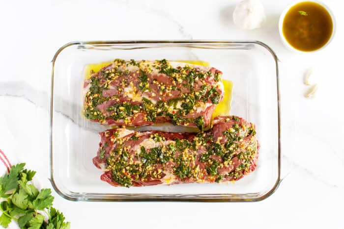 grilled hanger steak uncooked in clear pan