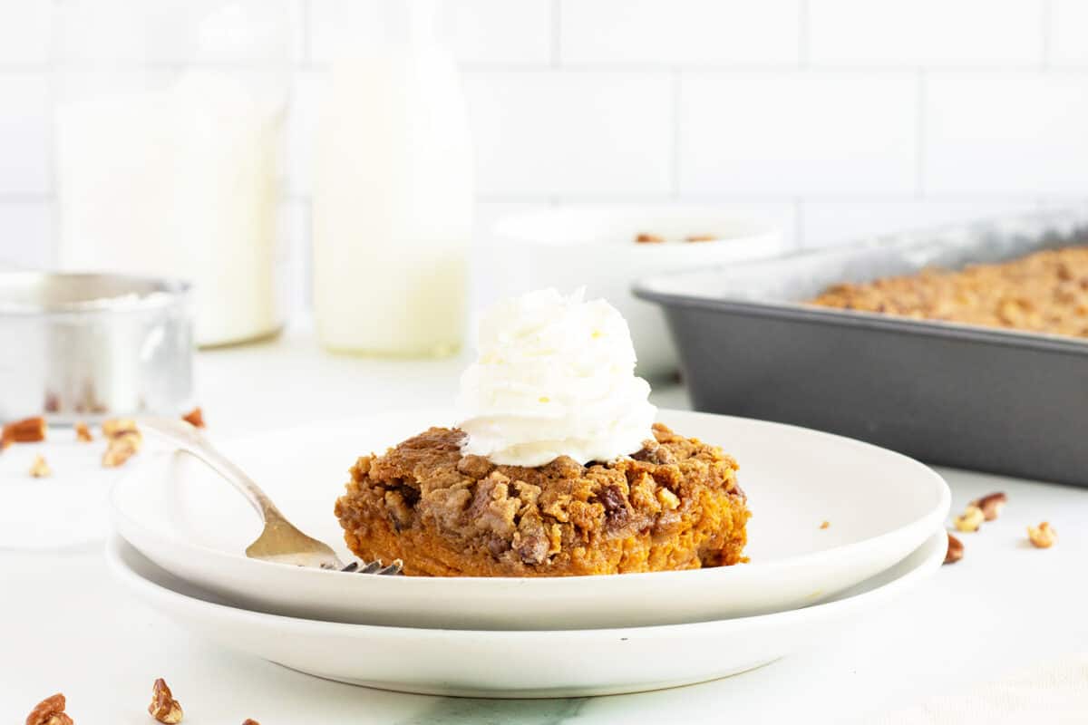 pumpkin dump cake on a white plate with a fork