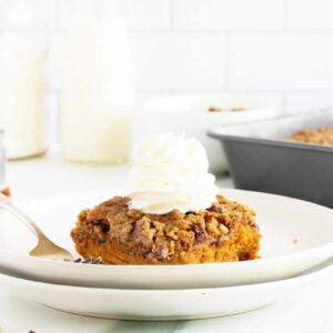 pumpkin dump cake on a white plate with a fork