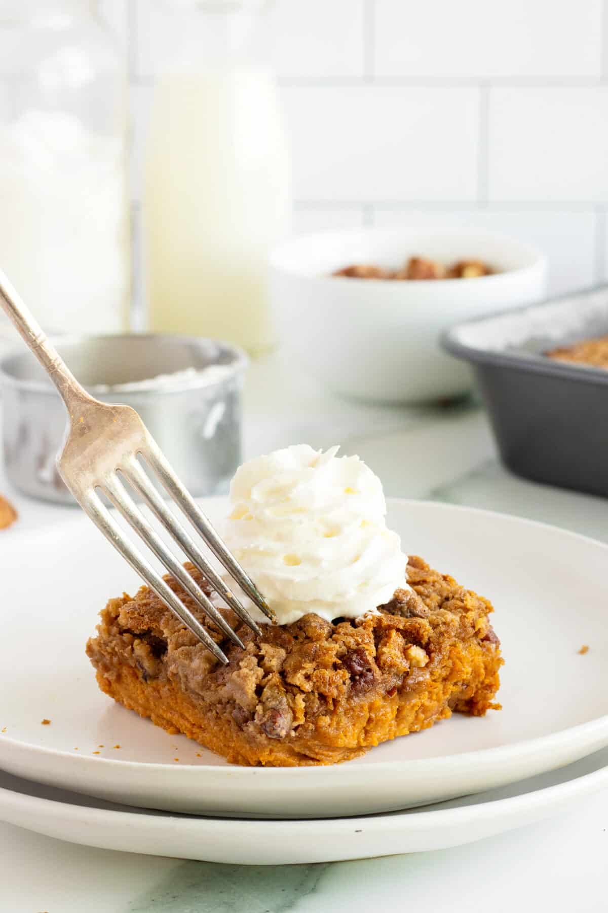 pumpkin dump cake on a white plate with a fork