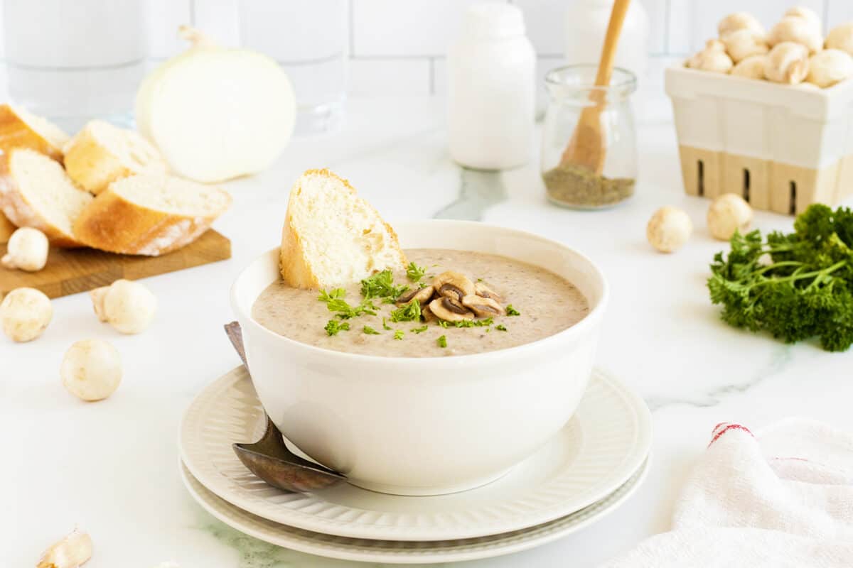 Cream of Mushroom Soup in a white bowl withbaguette