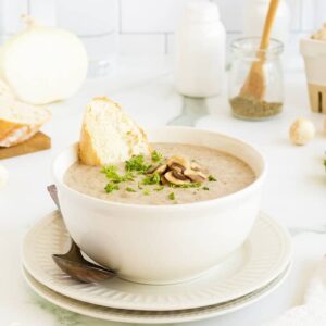 Cream of Mushroom Soup in a white bowl withbaguette