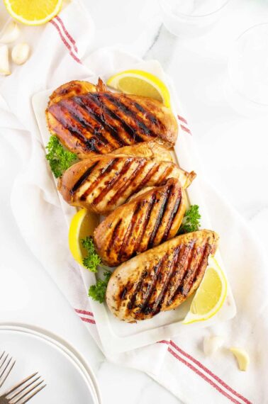 Grilled Chicken Breasts in a line on a cutting board
